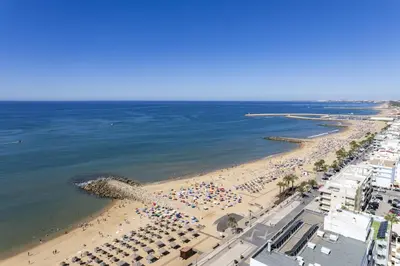 an aerial view of a beach with crowds of people at Terracos de Quarteira II Yellow by Real Properties in Quarteira