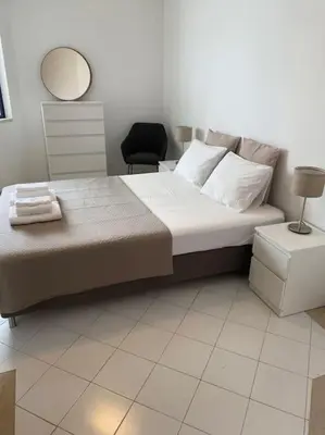 a bedroom with a bed with a mirror and a chair at Casa Porto Marina in Vilamoura