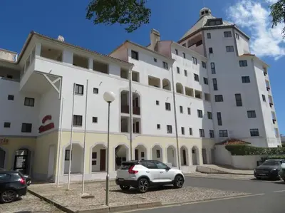 a white building with a car parked in front of it at Casa Porto Marina in Vilamoura
