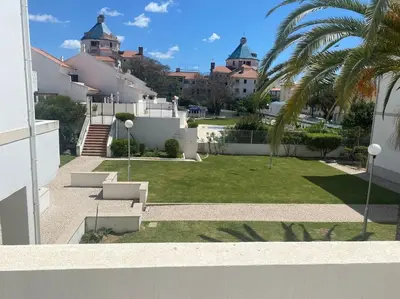 a view of a yard with a palm tree and buildings at Casa Porto Marina in Vilamoura
