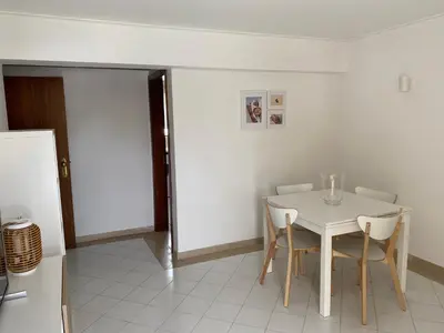 a white dining room with a white table and chairs at Casa Porto Marina in Vilamoura