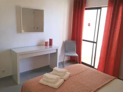 a bedroom with a desk and a bed with towels at Casa Vila Magna T1 in Albufeira