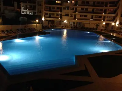 a large swimming pool in a building at night at Casa Vila Magna T1 in Albufeira