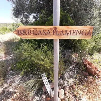 a wooden sign on a pole in a field at B&B Casa Flamenga in Alte