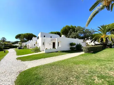 a white house with a palm tree and a gravel road at Albufeira Balaia Golf Vilage 3 With Pool by Homing in Albufeira