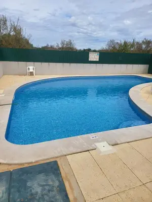 a large blue swimming pool with a chair next to it at Flor do Campo in Albufeira