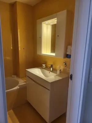a bathroom with a sink and a tub and a mirror at Flor do Campo in Albufeira