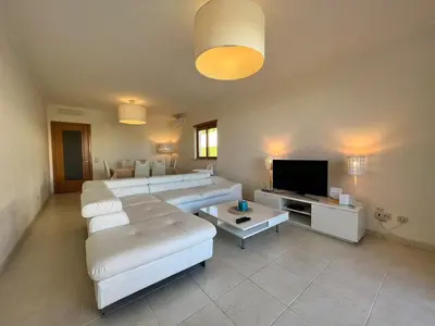 a living room with white furniture and a flat screen tv at Villa Durban in Albufeira