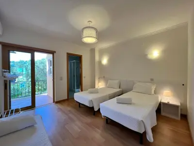 a bedroom with two beds and a couch and a balcony at Villa Durban in Albufeira