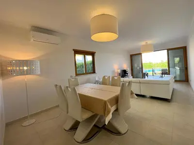 a dining room with a table and chairs and a couch at Villa Durban in Albufeira