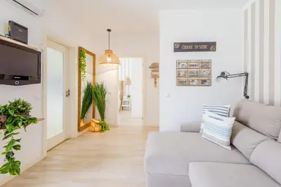 a living room with a couch and a hallway at Alfamar Apartment at Praia da Falesia in Albufeira