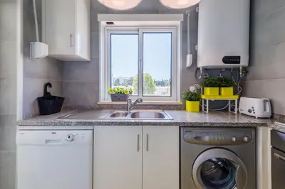 a kitchen with a sink and a washing machine at Alfamar Apartment at Praia da Falesia in Albufeira