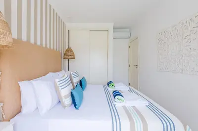 a bedroom with a bed with blue and white pillows at Alfamar Apartment at Praia da Falesia in Albufeira