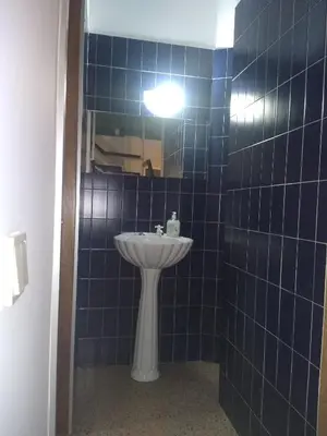 a blue tiled bathroom with a sink and a mirror at Melaya Private Rooms in Faro
