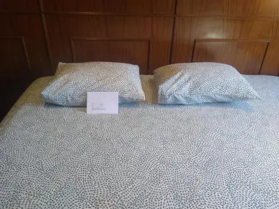 a bed with two pillows and a sign on it at Melaya Private Rooms in Faro