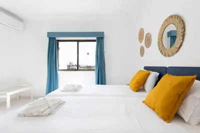 a bedroom with a bed and a desk and a window at #189 Montechoro Flat by Home Holidays in Albufeira