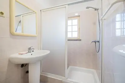 a white bathroom with a sink and a shower at Villa Nina in Albufeira