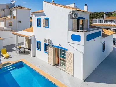 a white house with a swimming pool in front of it at Villa Nina in Albufeira