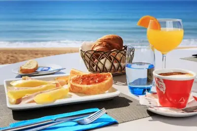 a table with a plate of food on the beach at Vale do Lobo Algarve,Exclusive Private Pool Villa in Vale do Lobo