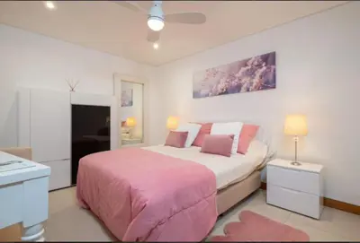 a bedroom with a large bed and a pink blanket at Vale do Lobo Algarve,Exclusive Private Pool Villa in Vale do Lobo
