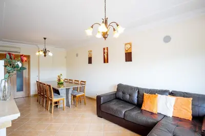 a living room with a leather couch and a table at Thiago Holidays Apartment in Albufeira