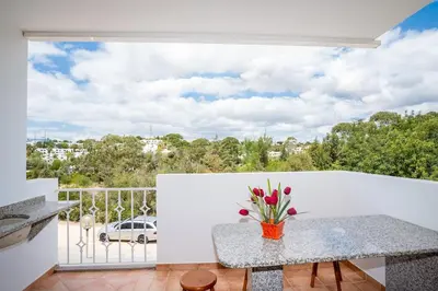 a balcony with a table with flowers on it at Thiago Holidays Apartment in Albufeira