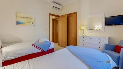 a bedroom with two beds and a couch and a tv at Greice Homes- 3 bed Luxury Apartment in Vilamoura in Quarteira