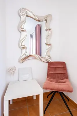 a mirror above a white table and a chair at Gale SunBeach Village - Jardins da Gale in Albufeira