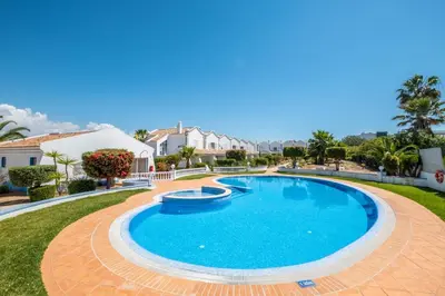 a swimming pool in a yard with houses in the background at Gale SunBeach Village - Jardins da Gale in Albufeira
