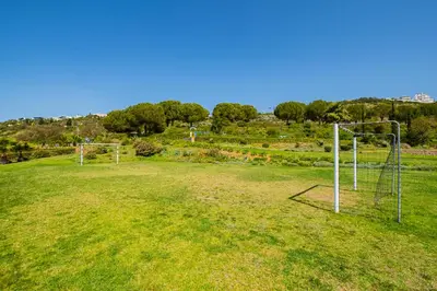 an empty field with two soccer nets in the grass at Achard Marina Apartment in Albufeira