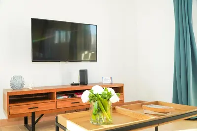 a living room with a tv and a vase of flowers on a table at Villa Catarina Ocean View in Albufeira