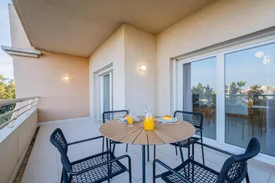 a kitchen with a table with a white table cloth at Barracuda Oura Dream Apartment in Albufeira