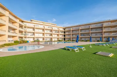 a swimming pool in front of a building at Barracuda Oura Dream Apartment in Albufeira
