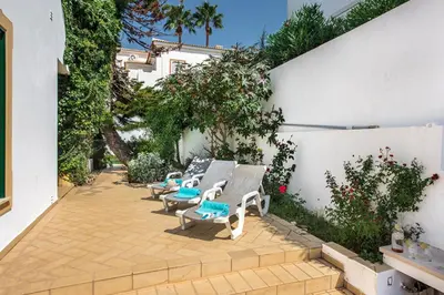 a patio with lounge chairs and a fence at Villa Jonas in Albufeira