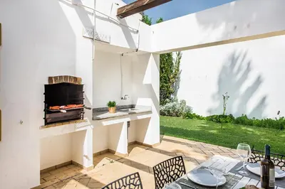 a patio with a fireplace and a table and chairs at Villa Jonas in Albufeira