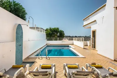 a swimming pool on the side of a house at Villa Jonas in Albufeira