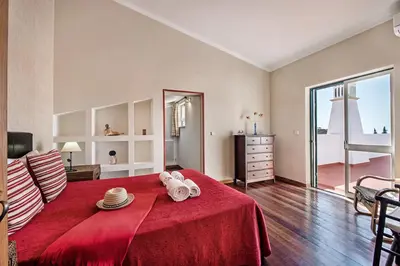 a bedroom with a red bed with a red blanket at Villa Jonas in Albufeira