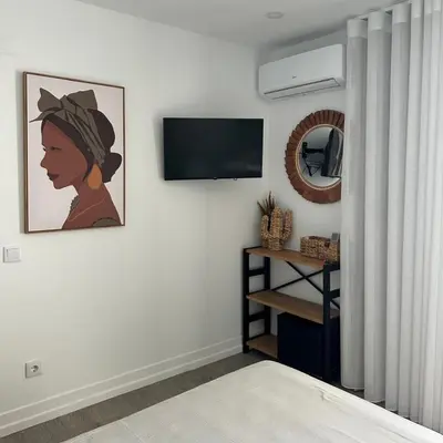 a living room with a flat screen tv on a wall at Malpique heated pool & Jacuzzi Guest House in Albufeira