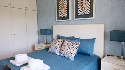 a bedroom with a bed with blue sheets and pillows at Carpe Diem Vilamoura By Dualhotels in Vilamoura