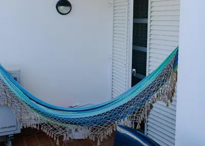 a hammock on the porch of a house at Carpe Diem Vilamoura By Dualhotels in Vilamoura