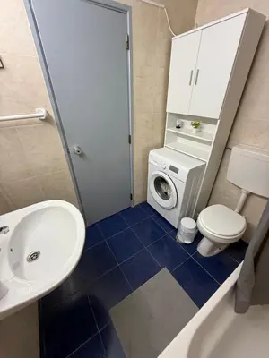 a bathroom with a toilet sink and a washing machine at Casa da Oura in Albufeira