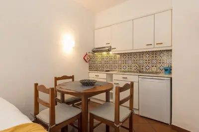 a kitchen with a table and chairs in a room at Apartamentos Pescadores in Albufeira