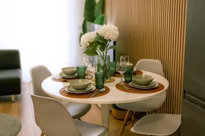 a table with chairs and a vase of flowers on it at Carmo House in Faro