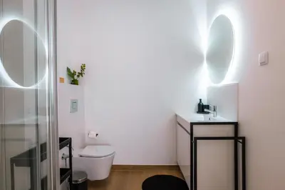 a bathroom with a toilet and a sink and mirrors at Carmo House in Faro
