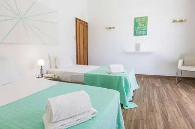 a room with two beds with green and white sheets at Villa Namora in Albufeira