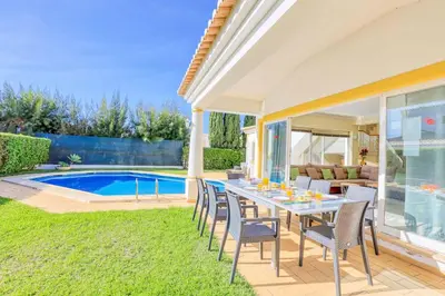 a patio with a table and chairs next to a pool at Villa Jeanic in Galé