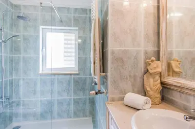 a bathroom with a tub and a sink and a shower at Villa Luz Figueiras in Galé