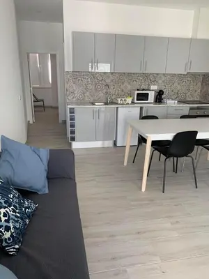 a living room with a couch and a table and a kitchen at CASA CANELAS in Faro