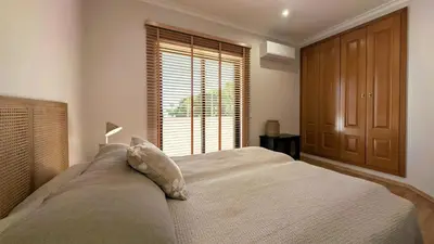 a bedroom with a large bed and a window at Villa Pinetree Seaside, Albufeira in Albufeira