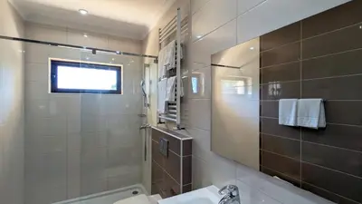 a bathroom with a sink and a toilet and a window at Villa Pinetree Seaside, Albufeira in Albufeira